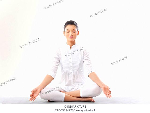 Young woman meditating over white background