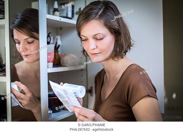 Woman reading medicine instruction sheet