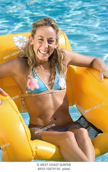 Portrait of Young Woman on Inflatable Raft in Pool