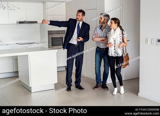 Real estate agent showing new house to couple