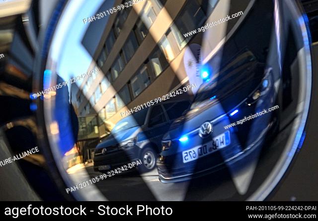 05 November 2020, Saxony, Zwickau: A VW Golf special police vehicle is reflected in the VW logo. Volkswagen Saxony and the Saxon police have signed a...