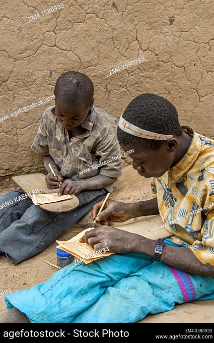 Dogon boys writing on wooden tablets in a Koran school in the Niogono Dogon Village in the Bandiagara area, Dogon country, Mali, West Africa