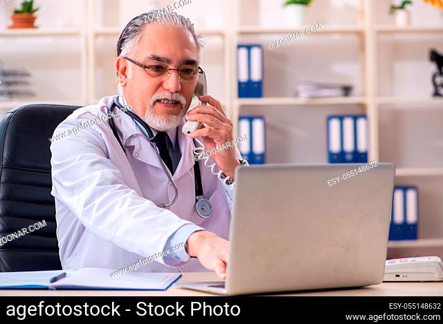 Aged male doctor working in the clinic