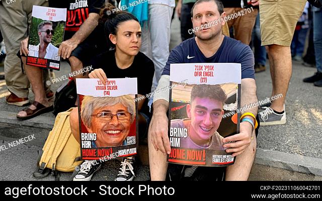 Relatives and friends of those kidnapped during the October 7 Hamas cross-border attack in Israel, hold photos of their loved ones during a protest calling for...