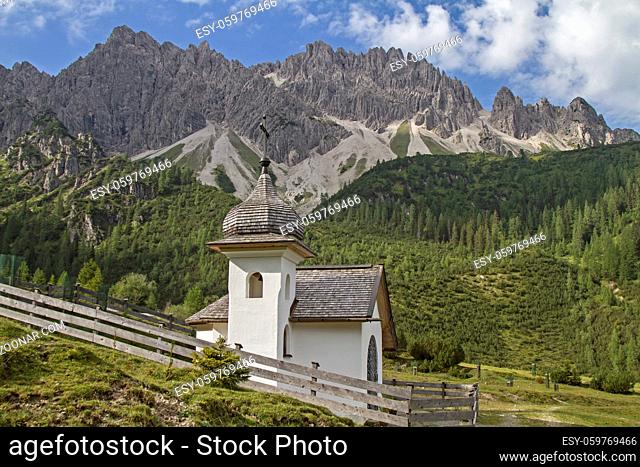 Kapelle vor der Erlspitzgruppe, die zum Karwendelgebirge gehört und bizarre Verwitterungsformen wie Türme, Felsnadeln und stark zerschartete Grate aufweist