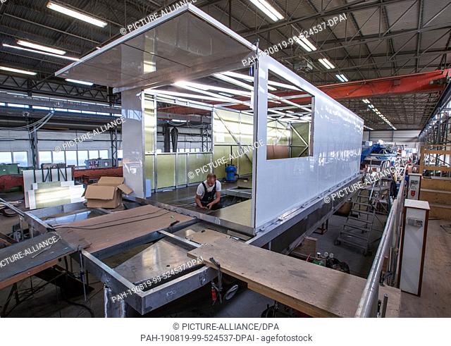 25 May 2019, Mecklenburg-Western Pomerania, Rechlin: A houseboat is overhauled in the Kuhnle shipyard shipbuilding hall. The boats intended for charter tours on...