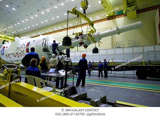 Workers prepare to attach the escape tower to the Soyuz MS-02 spacecraft during assembly of the Soyuz rocket on Friday, Oct