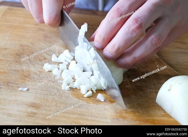 Cutting onions on a cutting board in the kitchen