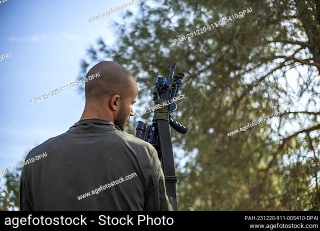 20 December 2023, Israel, ---: An Israeli soldier holds his weapon near the Israeli Gaza border, amid continuing battles between Israel and the Palestinian...