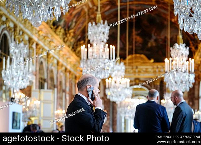 dpatop - 11 March 2022, France, Versailles: German Chancellor Olaf Scholz (SPD) speaks on the phone on the sidelines of the meeting of European Union EU heads...