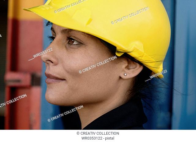 female architect wearing a yellow safety helmet at a construction site