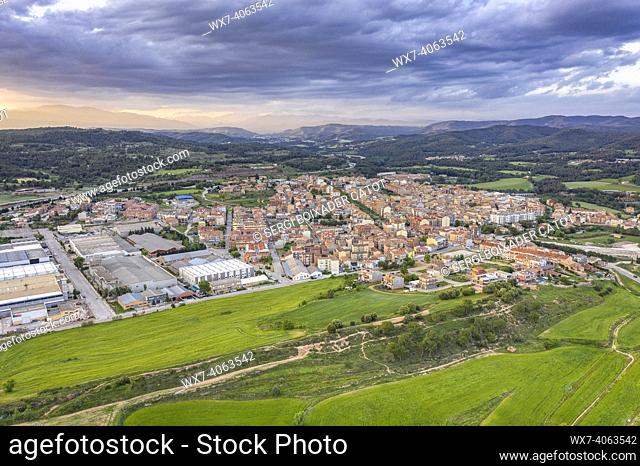 Aerial view of the town of NavÃ s and the Mujal greenway between spring fields (Bages, Barcelona, Catalonia, Spain)