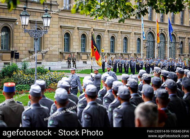 14 September 2023, Bavaria, Munich: Soldiers carry the German flag along the rows of recruits during a ceremonial pledge by around 180 recruits from Mountain...