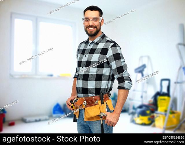 happy male worker or builder with tool belt