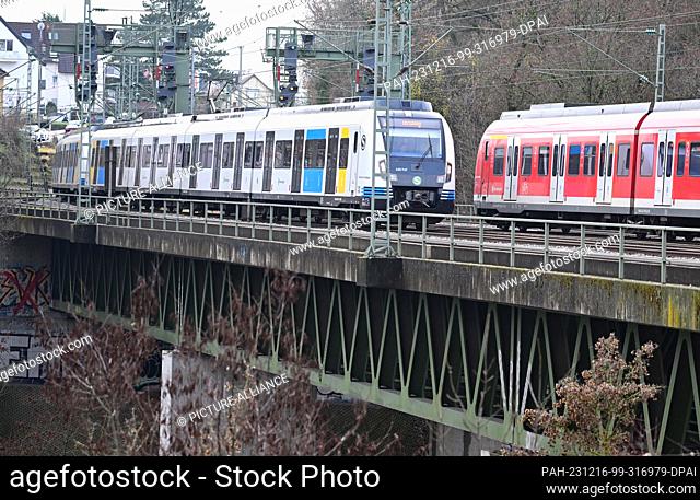 PRODUCTION - 15 December 2023, Baden-Württemberg, Stuttgart: Two S-Bahn trains run over the Nesenbach viaduct in Stuttgart-Vaihingen