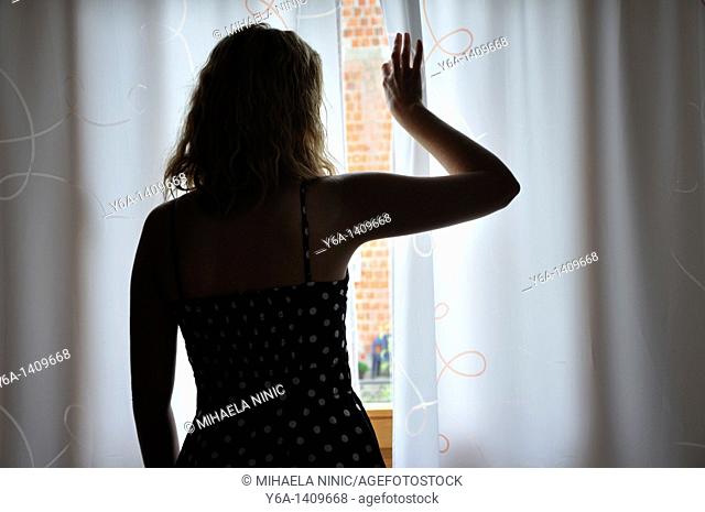 Woman looking trough window