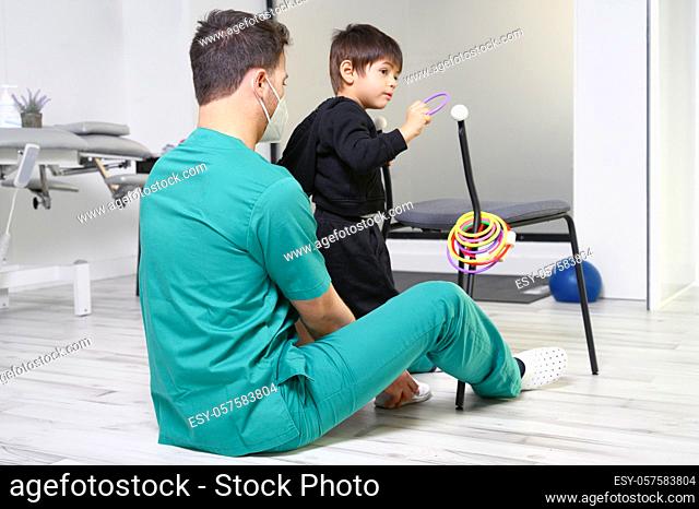 Child with cerebral palsy on physiotherapy in a children therapy center. Boy with disability doing exercises with physiotherapists in rehabitation centre