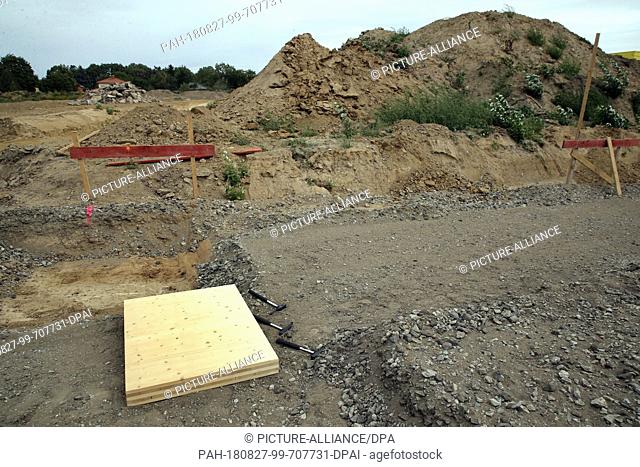 27 August 2018, Berlin, Germany: A foundation stone made of wood lies in the construction pit in the district of Marzahn-Hellersdorf in the district of...