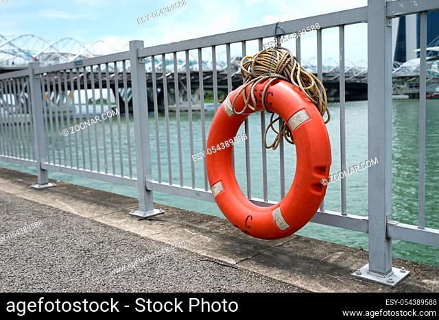 orange buoy on steel railing on shore