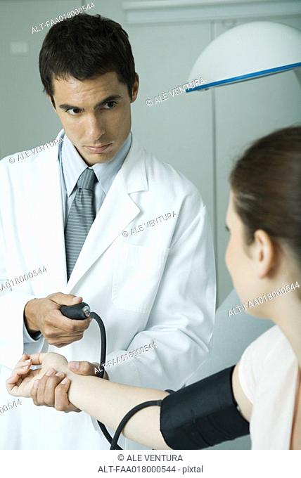 Doctor taking woman's blood pressure