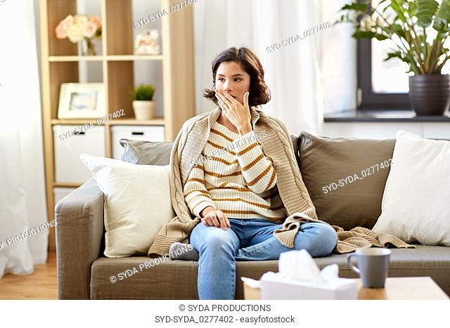 sick woman in blanket coughing at home