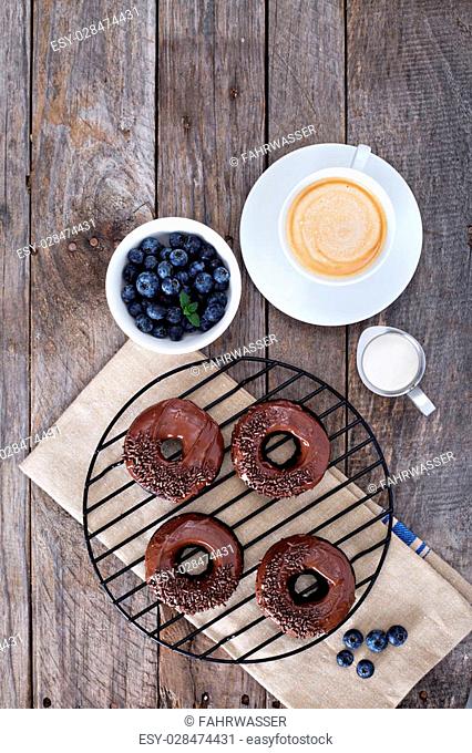 Chocolate gluten free donuts with coffee and blueberries