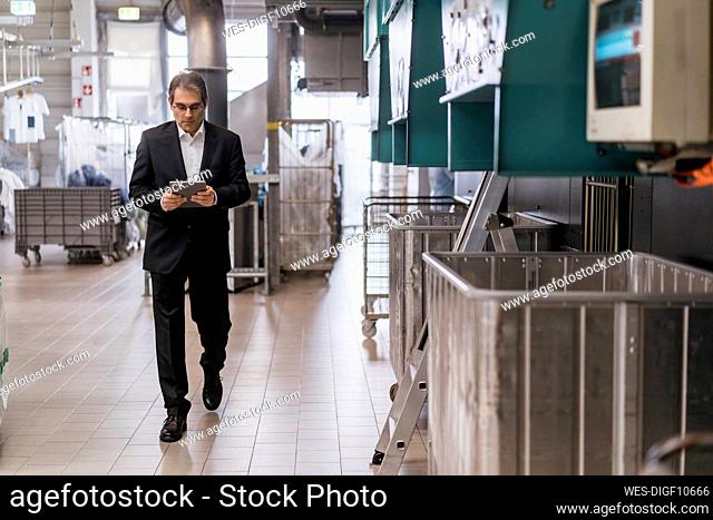 Mature businessman using tablet in a factory