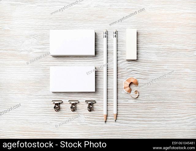 Blank stationery set. White business cards, pencil and eraser on light wooden background. Flat lay