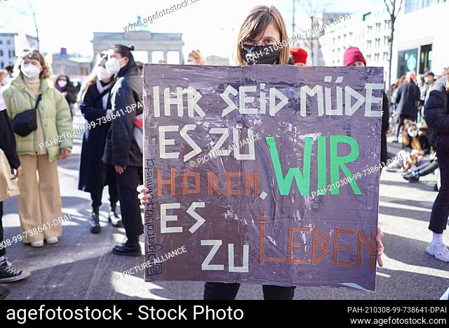 08 March 2021, Berlin: A sign reading ""You are tired of hearing it, we are tired of living it"" is carried by a woman at a demonstration for International...