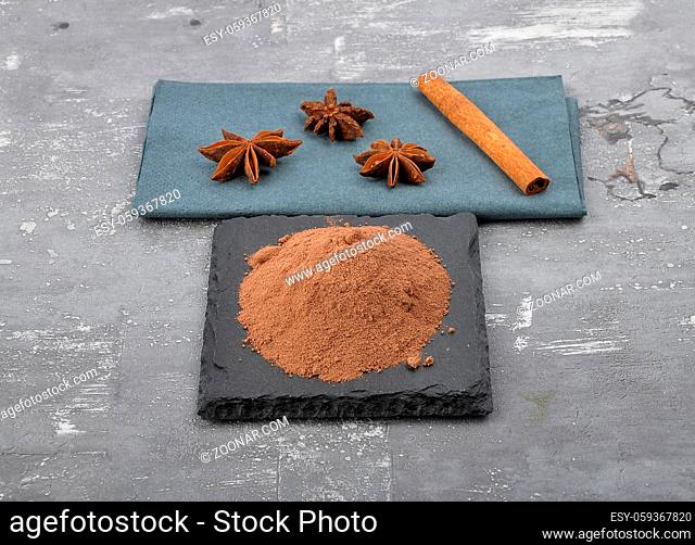 Kakao, Zimtstange und Sternanis auf Beton - Cocoa powder, cinnamon stick and star anis on concrete
