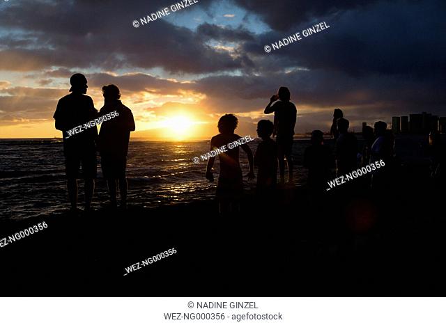 USA, Hawaii, Oahua, people watching sundown at Waikiki Beach