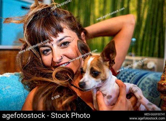 Close-up of hippie woman with chihuahua on sofa at home