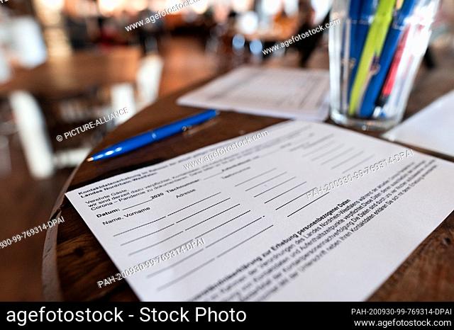 30 September 2020, North Rhine-Westphalia, Dortmund: ILLUSTRATION - A slip of paper for the contact details of guests is located in a restaurant in Dortmund In...