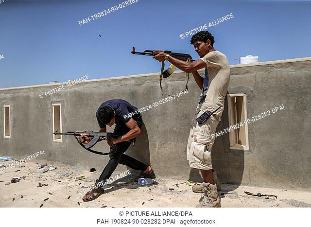 24 August 2019, Libya, Tripoli: Fighters of Libya's UN-backed Government of National Accord (GNA) of Fayez Serraj, fire their rifle during clashes with forces...