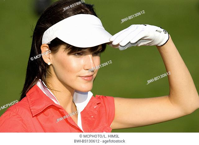 female golfer with white cap looking for the ball