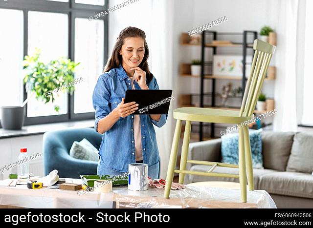 woman with tablet pc and old chair for renovation