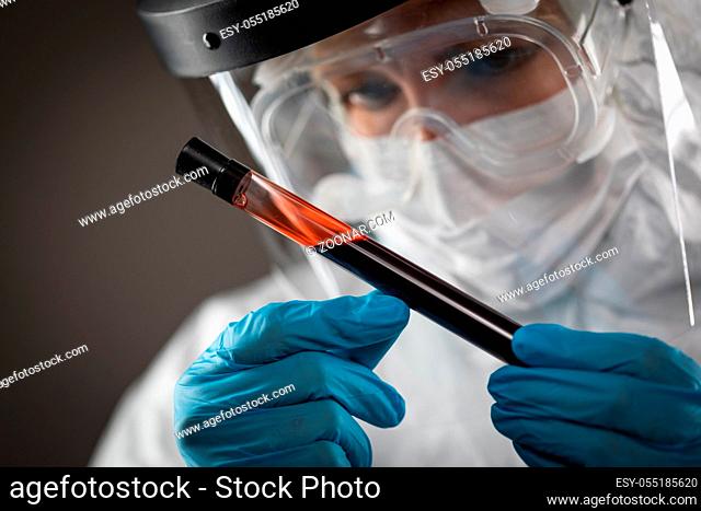 Female Lab Worker Holds Test Tube of Blood For Testing