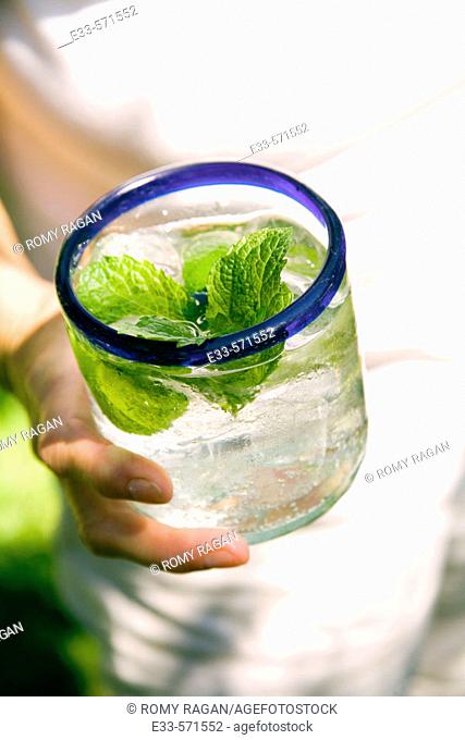 Person holding glass of mineral water