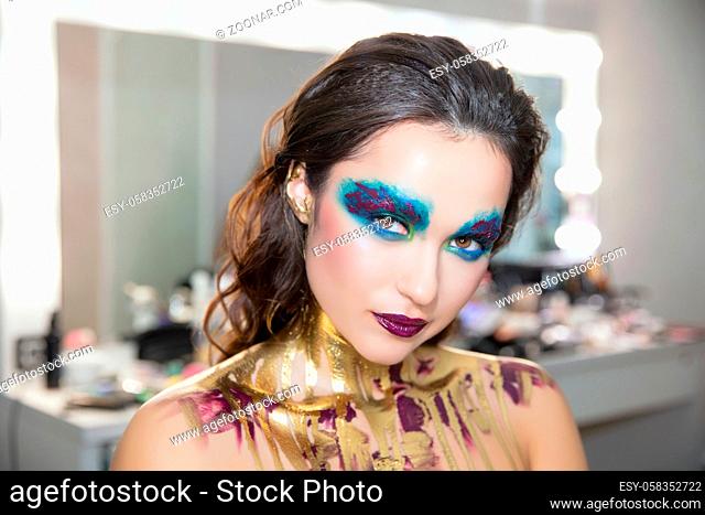 Young beautiful brunette with creative make up and body painting