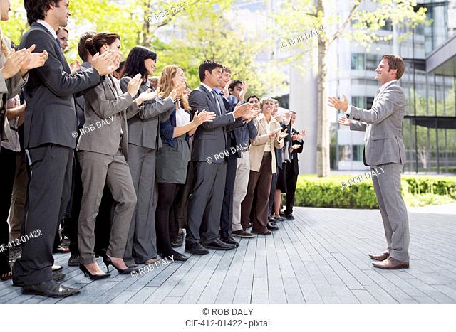 Crowd of business people cheering for businessman