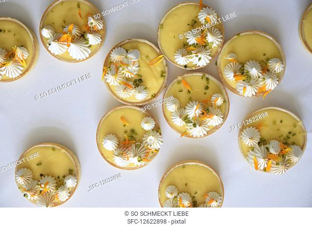 Lemon and passion fruit cakes with meringue dots and flower petals