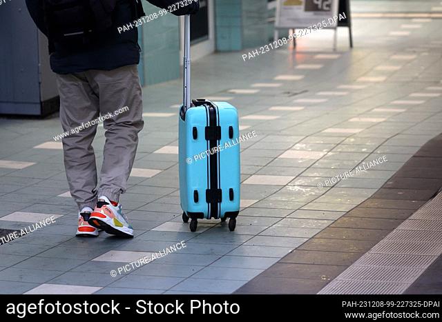 08 December 2023, Mecklenburg-Western Pomerania, Schwerin: A traveler with his suitcase on wheels at the main station. The German Train Drivers' Union (GDL) has...