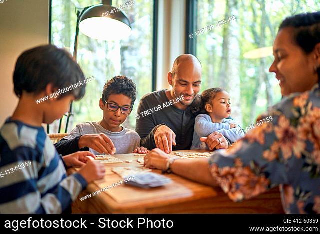 Family playing scrabble at dining table