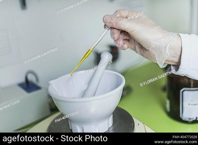 A worker in a pharmacy uses a disposable pipette for virgin olive oil in the recipe, photographed in a pharmacy in Niesky, April 13, 2023