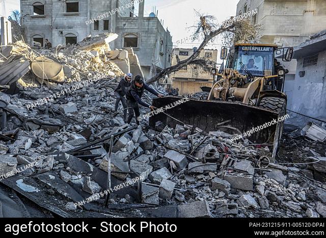 15 December 2023, Palestinian Territories, Rafah: Palestinians remove debris from damaged houses after Israeli air strikes on Rafah in the southern Gaza Strip
