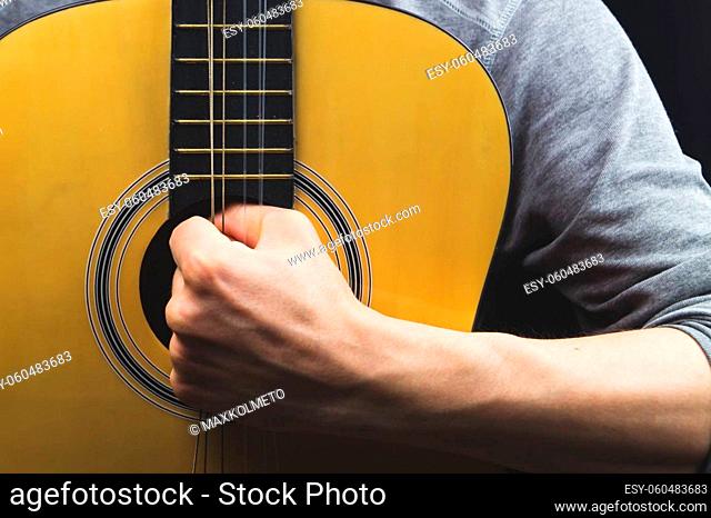Man holds acoustic guitar. string instrument
