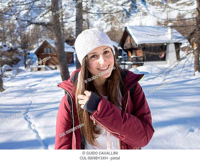 Young woman in knit hat in snow covered forest, portrait, Alpe Ciamporino, Piemonte, Italy