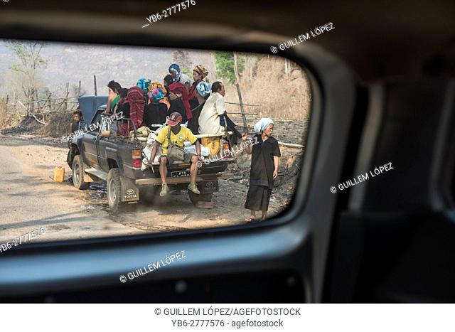 Crowded vehicle in a dirt road seen through a car window, Loikaw, Kayah State, Myanmar