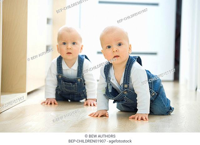 Baby twins crawling on the floor