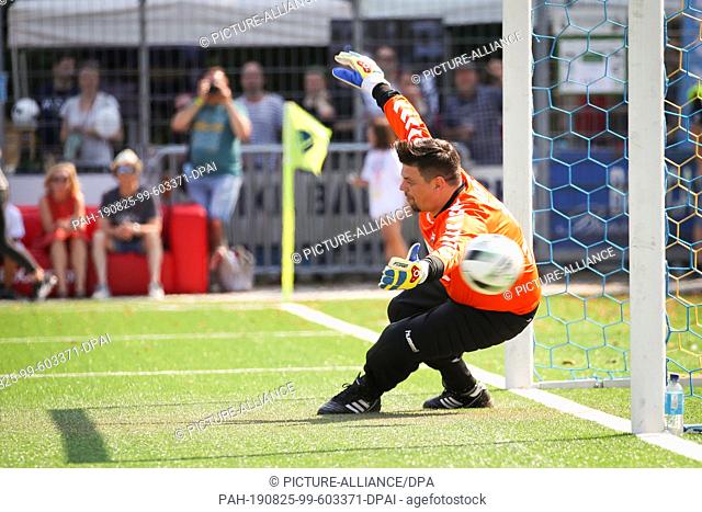 25 August 2019, Hamburg: Tim Mälzer, restaurateur and cook, fails on a penalty kick in the charity football game ""Kicken mit Herz"" in the Hoheluft stadium